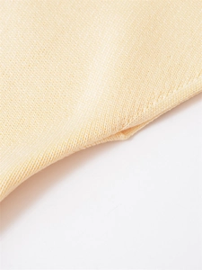Close-up detail of soft beige knitted fabric texture with dense vertical weave pattern