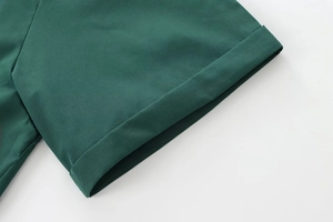 Detailed view of dark green poplin shirt cuffs featuring neat stitching and flat seams