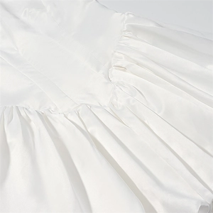 Detailed macro view of white satin dress fabric showing fine pleats and pleated craftsmanship