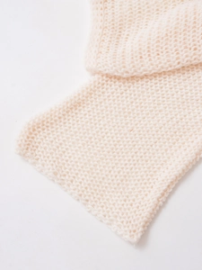 Detail of soft cream white knit texture showing premium thick woven yarn craftsmanship