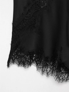 Close-up of elegant black satin hem featuring intricate eyelash lace trim and refined texture