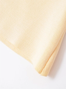 Macro shot of soft cream yellow ribbed knit fabric showing fine texture and elastic finish