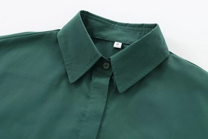 Close-up of dark green poplin shirt collar with buttons and size S label detail