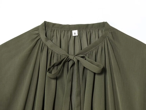 Detail view of olive green chiffon blouse featuring pleated neckline and bow tie design
