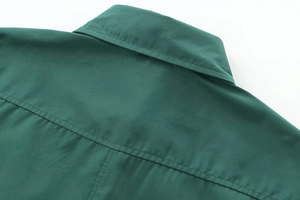 Close-up of lapel and back yoke stitching on dark green poplin casual shirt