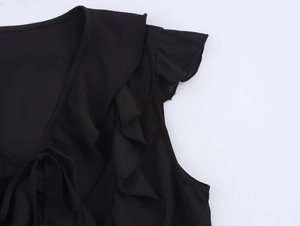 Vue détaillée des volants noirs et du col en V avec lien sur cette blouse en mousseline