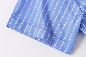 Detail of blue and white vertical striped poplin fabric with neat cuffed sleeve stitching