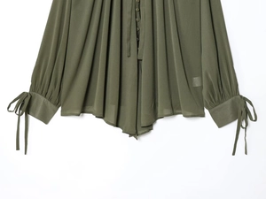Detail of olive green chiffon blouse featuring pleated texture and tied lantern sleeves