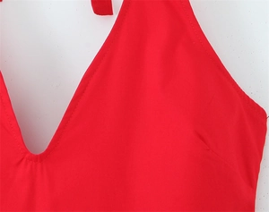 Détail d'une robe licou rouge avec décolleté en V profond et cordons de serrage au cou