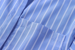 Detail shot of blue and white striped poplin shirt showing the chest pocket and stitching