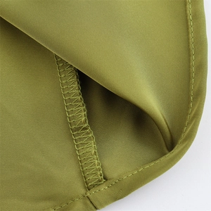 Detail view of olive green satin dress fabric featuring durable double stitching and overlock