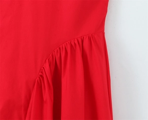 Détail de la robe rouge montrant le tissu plissé froncé et les coutures incurvées