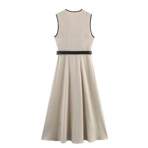 Detail of beige linen-texture dress featuring black piping and matching waist belt