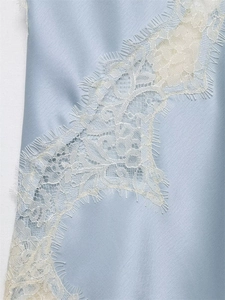Detail of light blue satin fabric with delicate creamy white floral lace edging trim