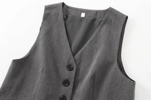 Gros plan détaillé du gilet gris foncé à col en V avec trois boutons et texture sergée