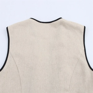 Macro detail of beige cotton linen dress with black trim and precise back stitching