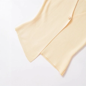 Minimalist pale yellow V-neck knit sweater vest featuring a single gold button detail