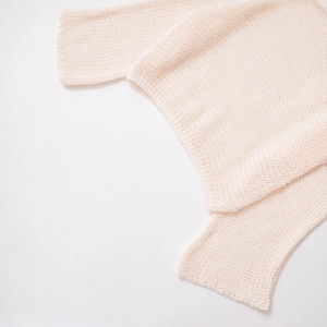 Pale pink knitted sweater with detailed openwork texture and soft minimalist design