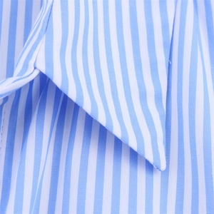 Gros plan sur le tissu popeline à rayures bleues et blanches avec surpiqûres du col