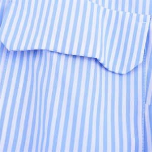Détail d'une robe chemise en popeline à rayures bleues et blanches avec rabat de poche