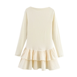 Détail d'une robe crème à manches longues pour fille avec ourlet à double volant doux