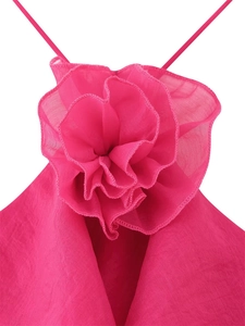 Detail of fuchsia ruffled chiffon dress featuring large handmade fabric floral accent