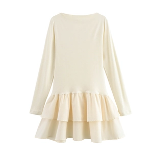 Détail de la robe crème à manches longues montrant l'ourlet à volants étagés doubles