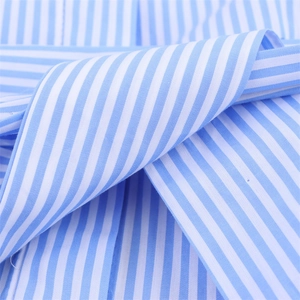Gros plan sur la texture du tissu popeline à rayures bleues et blanches de la robe