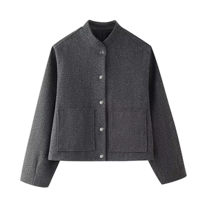 Detail view of dark grey wool jacket featuring silver snap buttons and large patch pockets