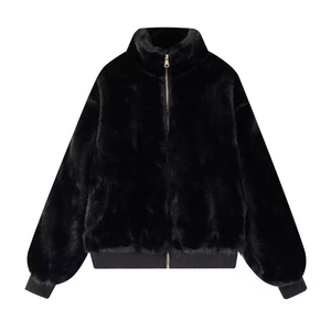 Detail of black faux fur jacket showing stand collar, gold zipper, and ribbed cuffs