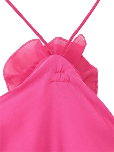 Detail of rose red dress featuring tiered ruffles and delicate criss-cross straps