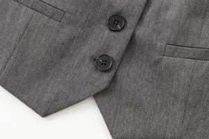 Détail du gilet en sergé gris foncé avec boutons en résine et poches passepoilées