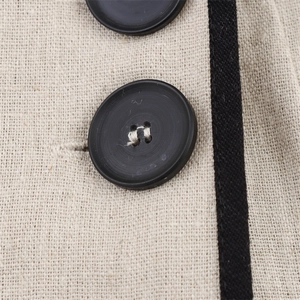 Macro detail of beige linen texture with black large buttons and contrasting fabric tape
