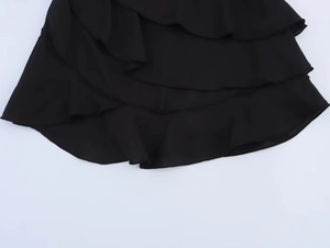 Détail de la jupe à volants noirs superposés avec un tissu léger et texturé