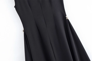 Detailed close-up of waistline featuring silver metal buckles on a black sleeveless dress