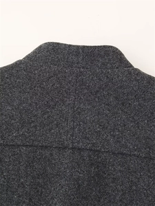Detail of dark grey wool jacket showing stitching craftsmanship and textured melange fabric