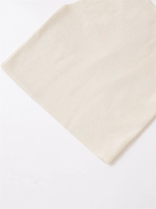 Detail shot of the beige knit vest fabric texture and high-quality flat hem finishing