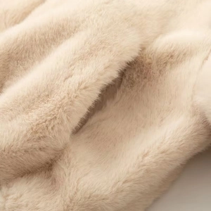 Detail of soft cream faux fur texture showing high density and natural luster on autumn jacket