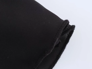Détail de l'ourlet roulé fin et de la texture textile noire de haute qualité de l'ensemble