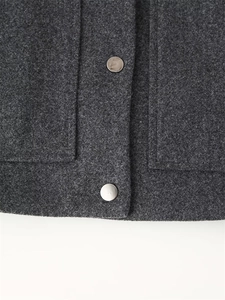 Close-up of deep gray wool blend jacket fabric with smooth silver metal buttons
