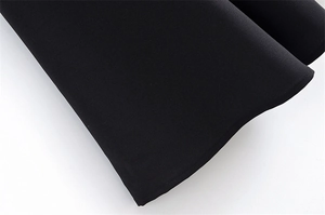 Close-up detail of the hem on a black sleeveless dress with fine woven texture and stitching