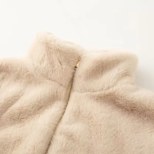 Close-up of soft faux fur texture on beige jacket with elegant gold metal zipper detail