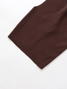 Close-up of dark brown knitted top showing high-density fabric and ribbed hem detail