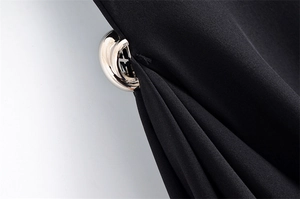 Detail of a polished gold metal buckle on high-quality black woven dress fabric