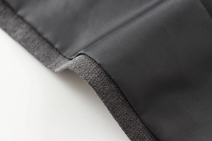 Gros plan sur le tissu gris chiné et la doublure lisse de l'ensemble de gilet à col V