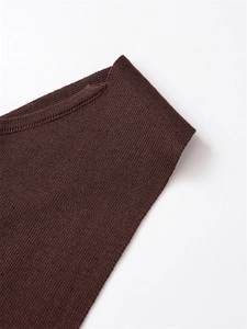 Detail of deep brown knitwear showing fine flat stitch texture and smooth neckline finish