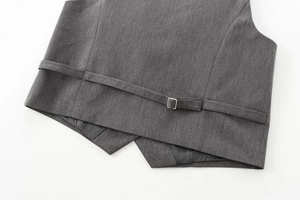 Détail de la sangle de taille réglable avec boucle en métal argenté sur un gilet gris