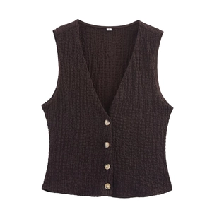 Detail of V-neck dark brown knit vest featuring textured fabric and tortoise buttons