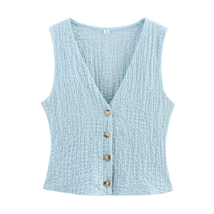Detail of light blue V-neck vest with textured pleated fabric and brown buttons