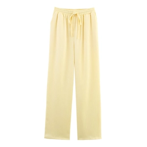 Detail of light yellow wide-leg trousers with elastic drawstring waist and pleated fabric